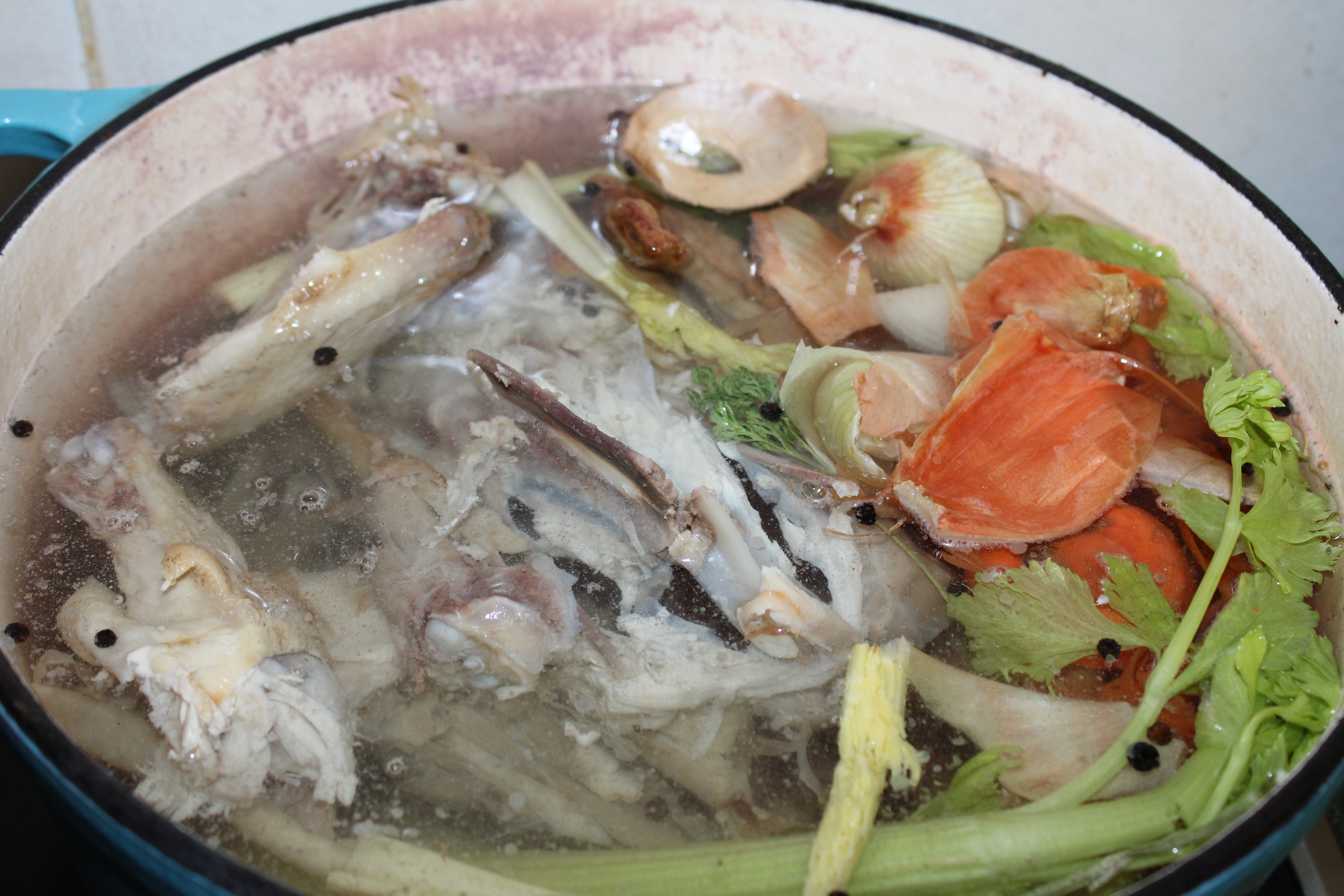 Chicken stock ingredients in pot on stove top